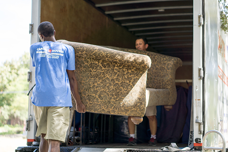 Two-Men-Moving-Couch-Into-Capital-Movers-Texas-Truck