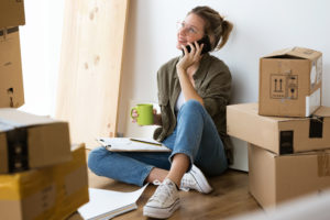 Woman-talking-on-phone-near-moving-boxes