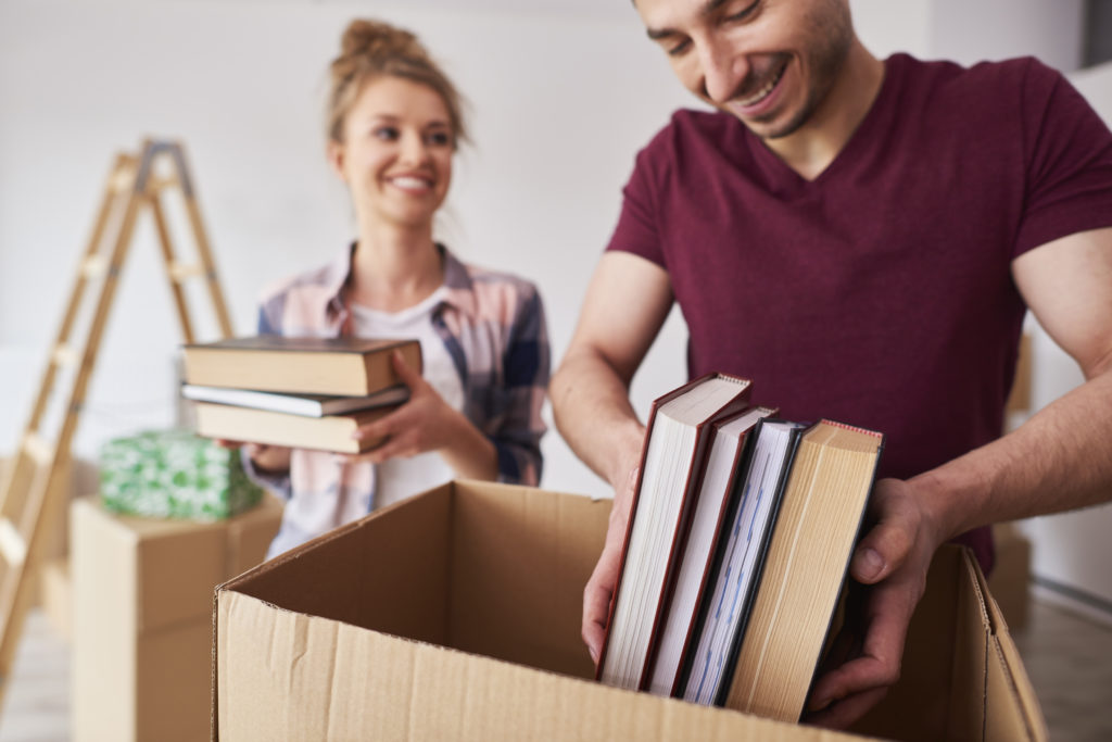 Young-couple-moving-books-into-box