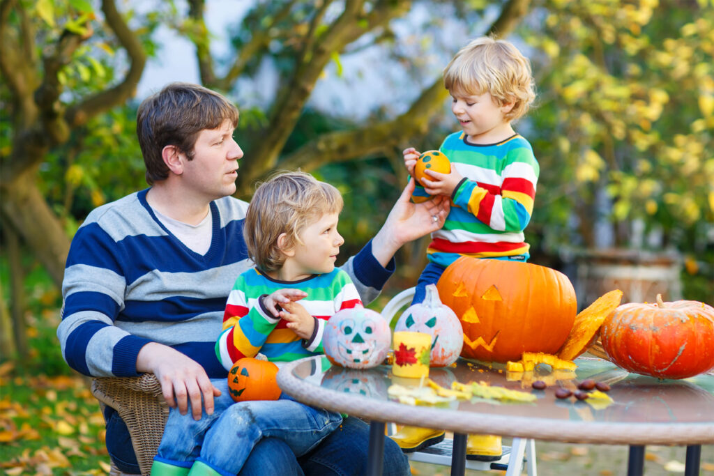 Portrait of an Austin dad and his two sons making jack-o-lantern for Halloween.