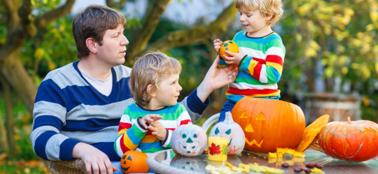 Portrait of an Austin dad and his two sons making jack-o-lantern for Halloween.